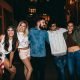 Group of young people celebrating outdoors posing for camera. Multi ethnic group of young friends enjoying in outdoor party.